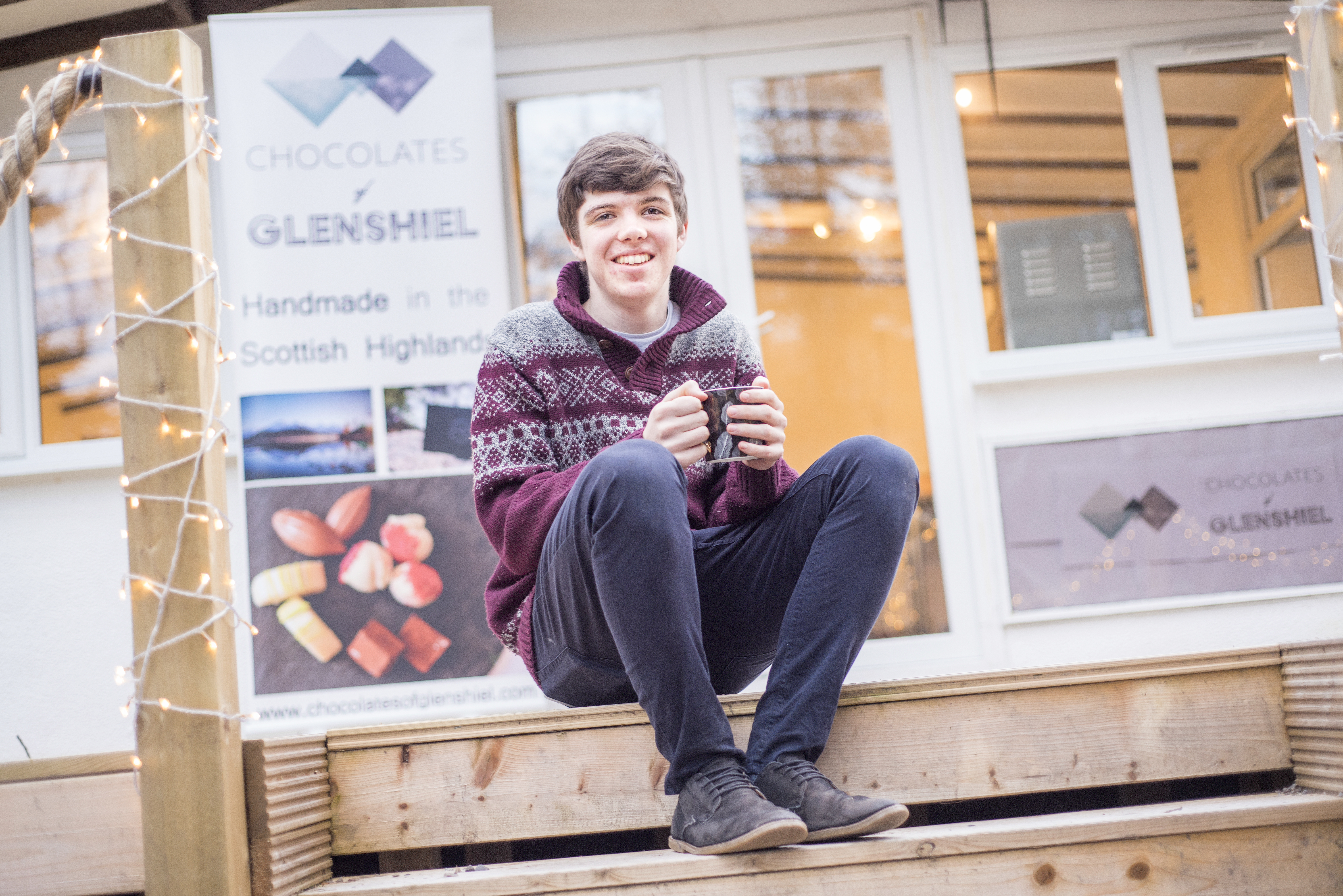 Young Highland chocolatier, Finlay Mackenzie, sitting outside his Wester Ross shop